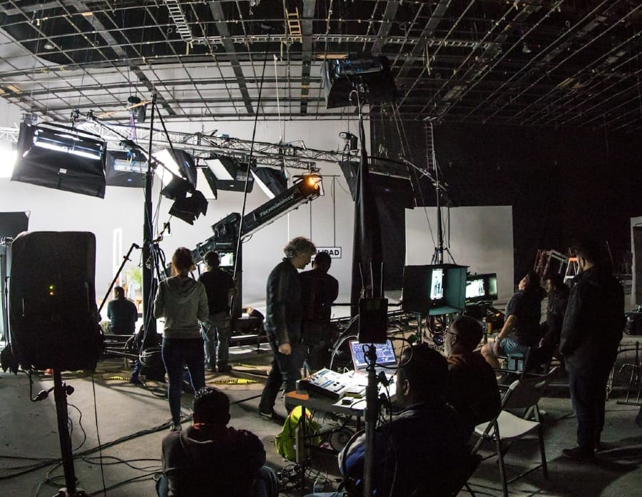 a group of people filming something on a set being managed by a manager