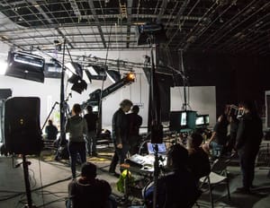 a group of people filming something on a set being managed by a manager